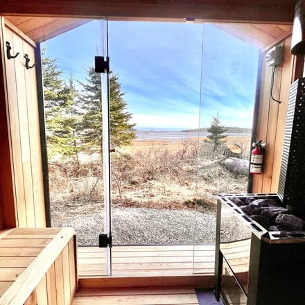 Cedar sauna interior with glass front looking out to the ocean estuary