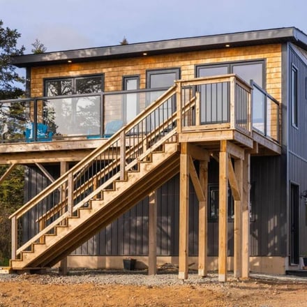 Exterior of the coastal retreat with elevated deck and timber staircase